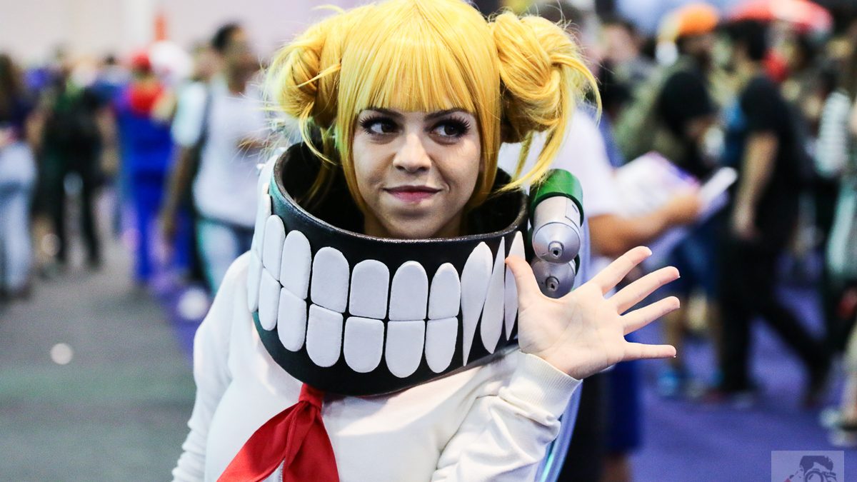 Visitante fantasiada de personagem de anime em corredor lotado de feira de games