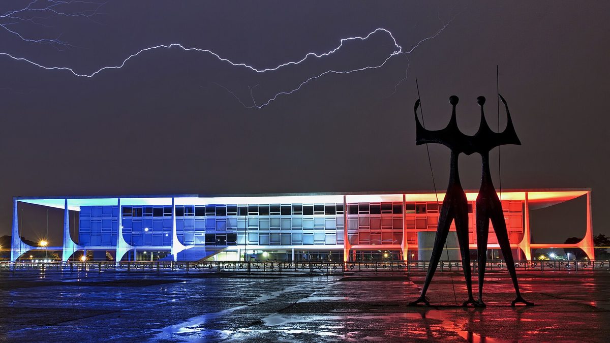 Raios sobre o Palácio do Planalto iluminado à noite, em Brasília