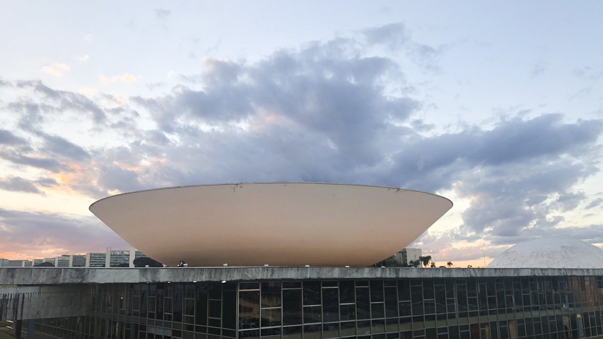 Cúpula da Câmara dos Deputados, em Brasília, sob céu com nuvens ao entardecer