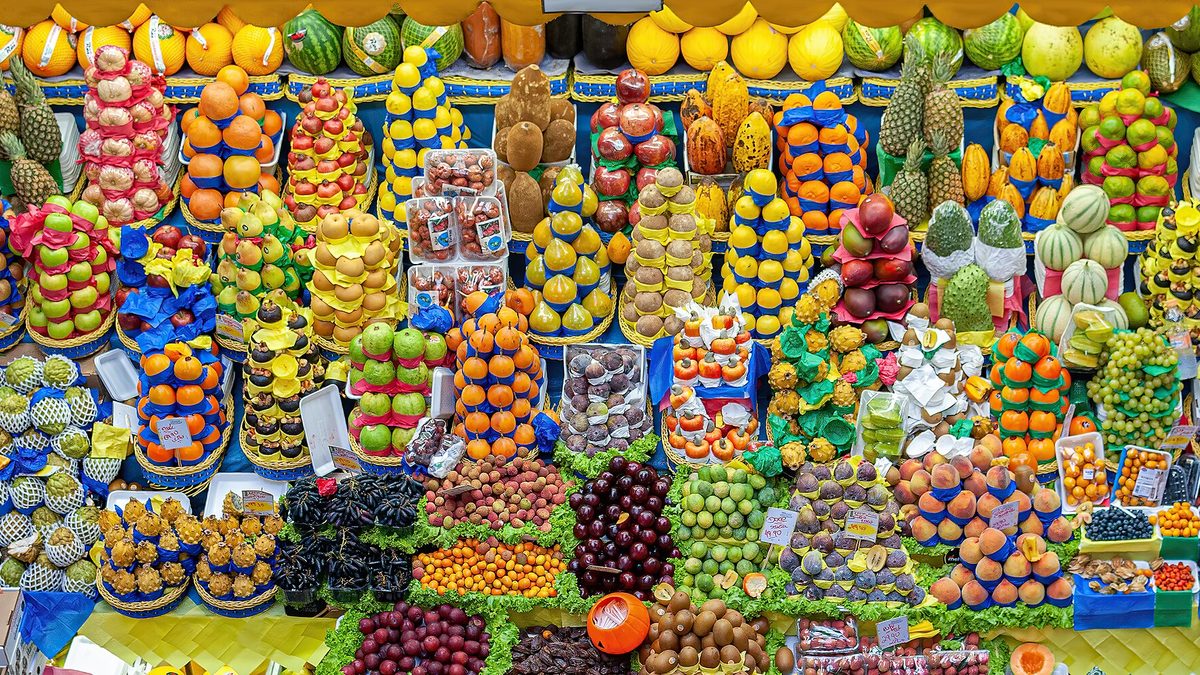 Banca de frutas coloridas empilhadas no Mercado Municipal de São Paulo