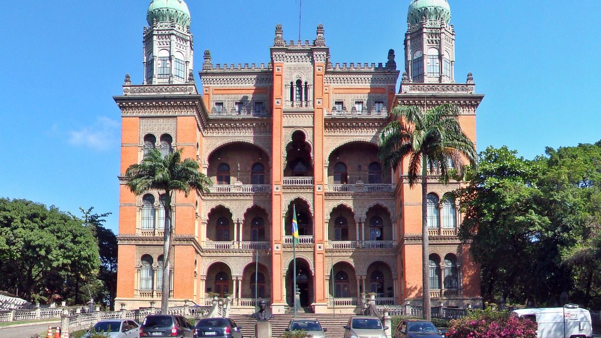 Castelo Mourisco da Fiocruz, prédio de tijolos com torres, sob céu azul no Rio de Janeiro
