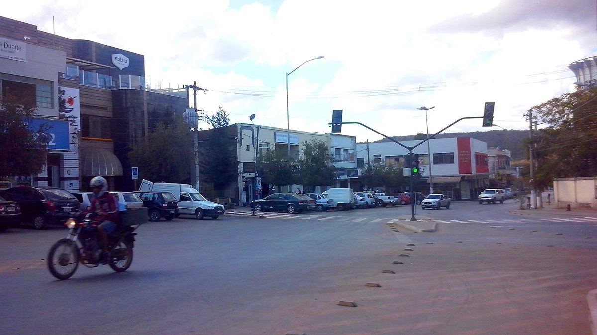 Cruzamento com semáforo, carros e lojas na entrada da Rua Rio Branco, em Lagoa Santa