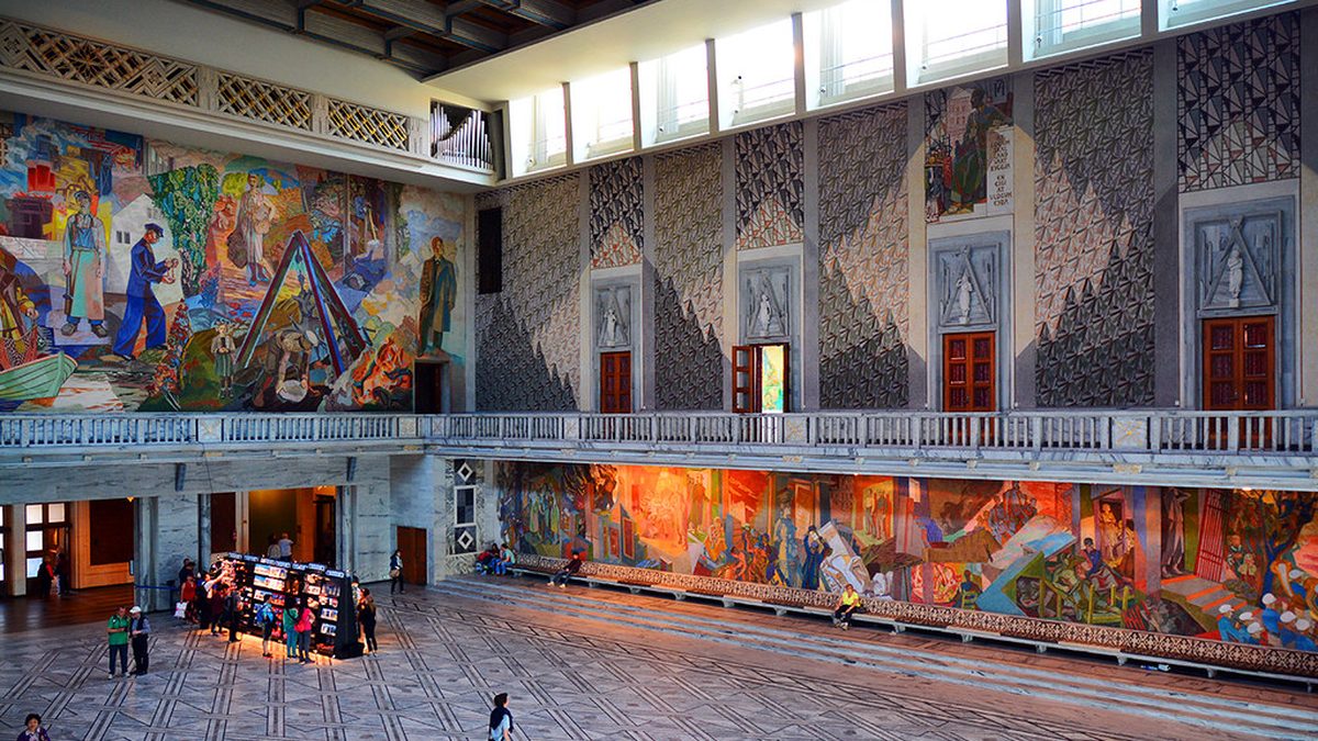 Salão principal da Prefeitura de Oslo, com murais coloridos nas paredes