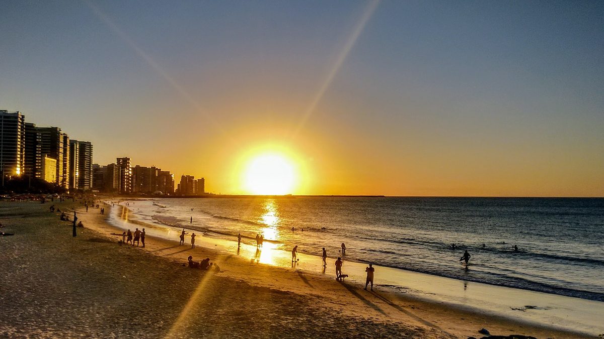 Pôr do sol sobre o mar e os prédios da orla de Fortaleza