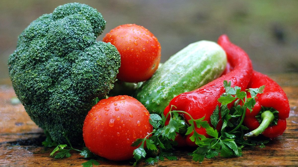 Brócolis, tomates, pepino e pimentão vermelho sobre uma mesa