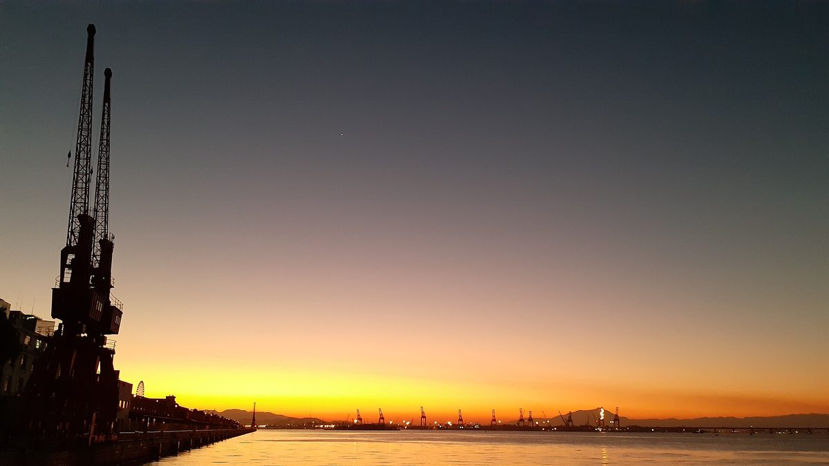 Silhueta de guindastes no cais do Porto do Rio de Janeiro ao entardecer